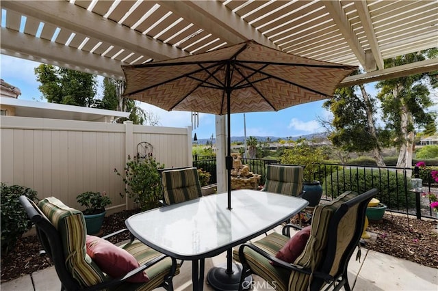 view of patio featuring outdoor dining area, fence, and a pergola