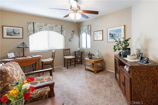 living area with light carpet, ceiling fan, and baseboards