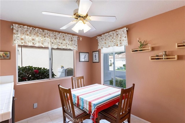 dining area featuring ceiling fan, baseboards, and tile patterned floors