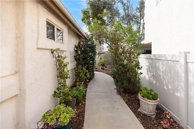 view of side of home with fence and stucco siding