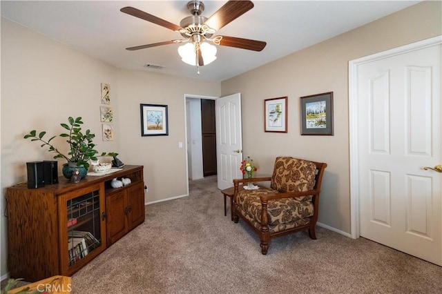 sitting room featuring baseboards, ceiling fan, visible vents, and light colored carpet