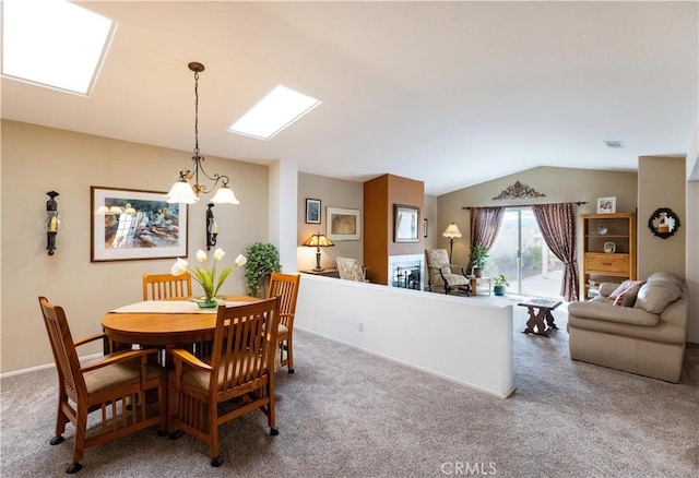 carpeted dining space featuring lofted ceiling with skylight, visible vents, and baseboards