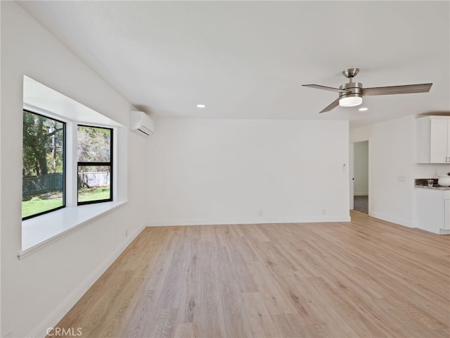 unfurnished living room featuring recessed lighting, a ceiling fan, light wood-style floors, baseboards, and an AC wall unit