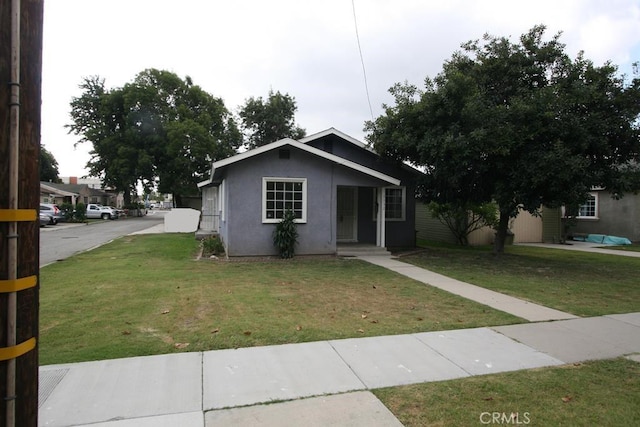 view of front of property featuring a front lawn and stucco siding