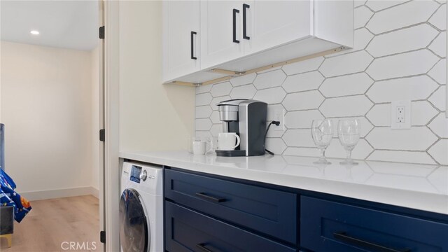 kitchen featuring white cabinetry, washer / dryer, blue cabinets, and light countertops