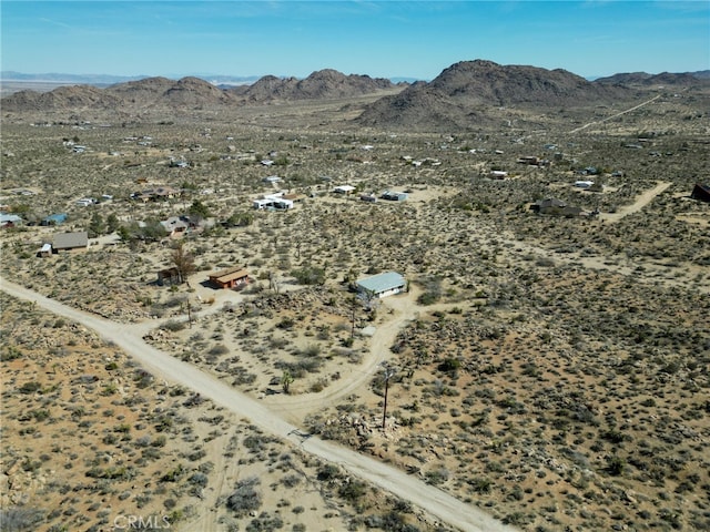 drone / aerial view featuring a mountain view and view of desert