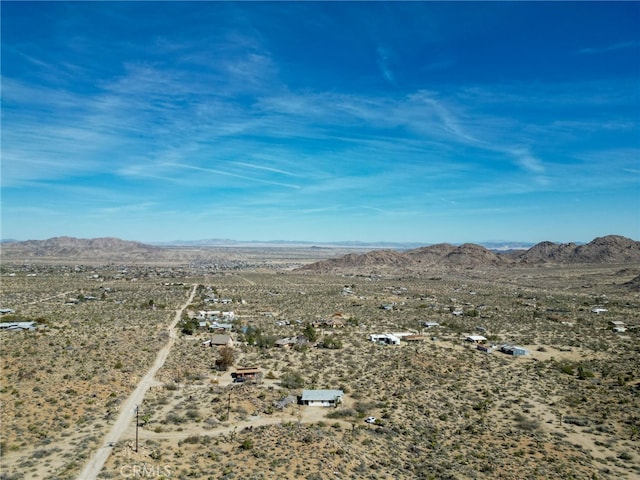 birds eye view of property with a mountain view and view of desert