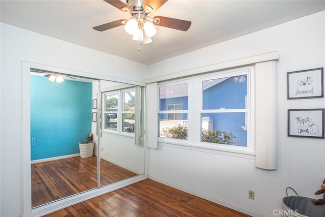 doorway to outside featuring a ceiling fan, baseboards, and wood finished floors