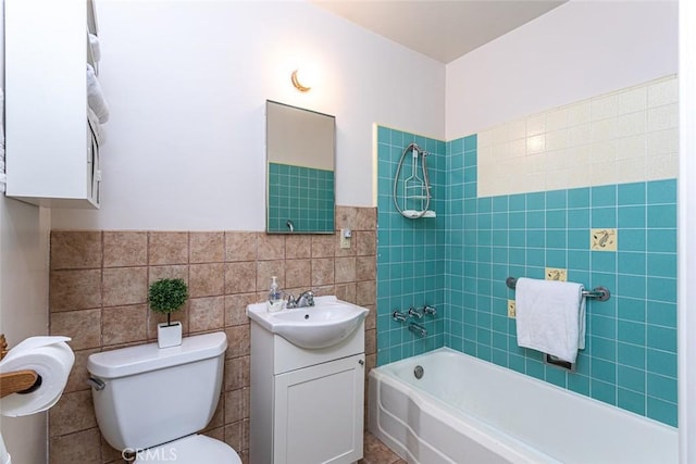 bathroom with shower / washtub combination, tile walls, toilet, and vanity