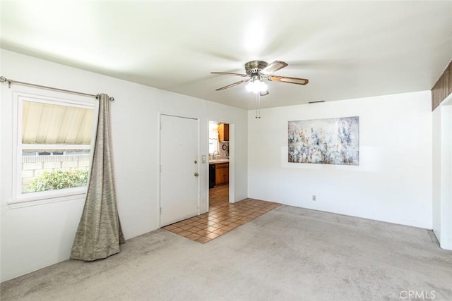 carpeted empty room featuring visible vents, ceiling fan, and a sink