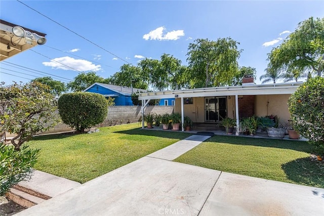 view of front of home with fence, a front lawn, and stucco siding