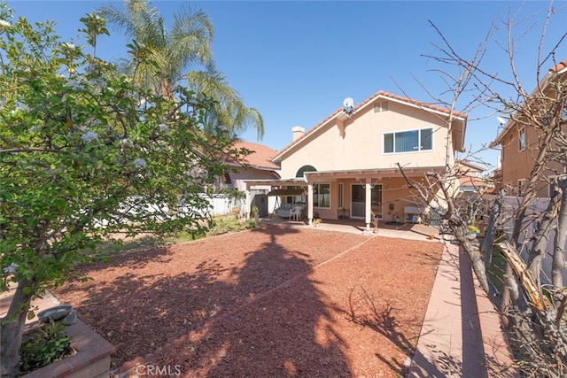 back of house with a patio area, a fenced backyard, and stucco siding