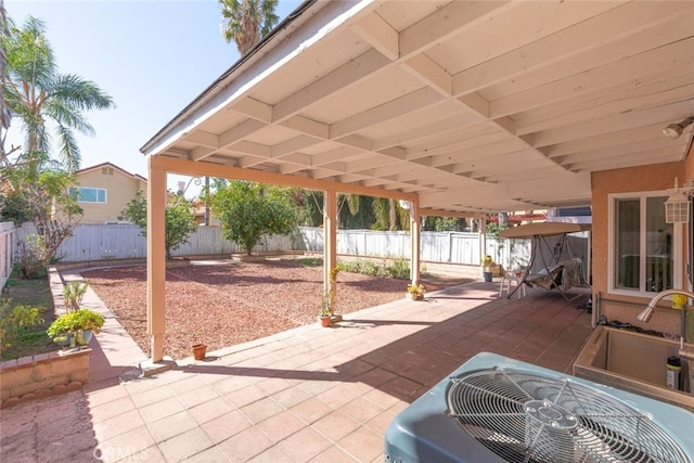 view of patio featuring a sink, a fenced backyard, and cooling unit