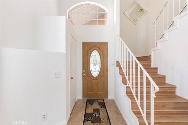 foyer featuring stairs and a high ceiling