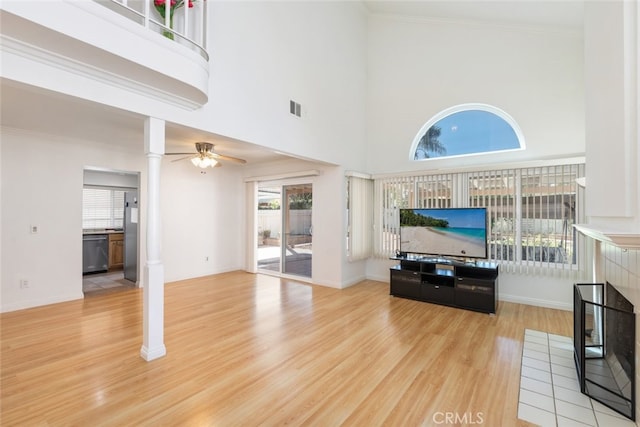 living area with visible vents, wood finished floors, and ornamental molding