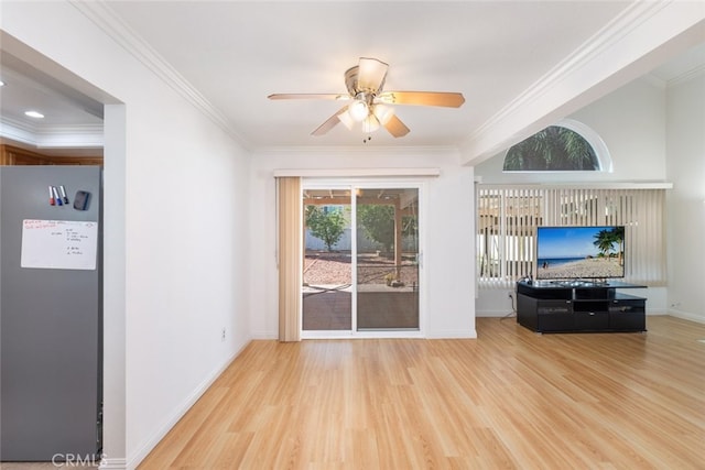 living area featuring ornamental molding, a ceiling fan, baseboards, and wood finished floors