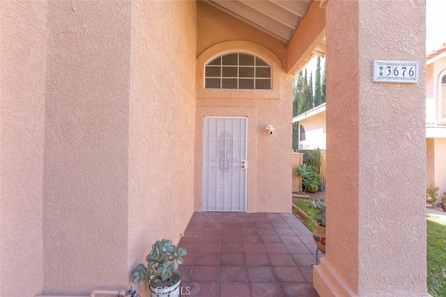 entrance to property featuring a patio area and stucco siding