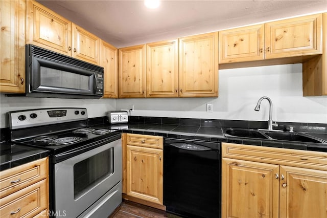 kitchen featuring light brown cabinets, black appliances, a sink, and tile counters