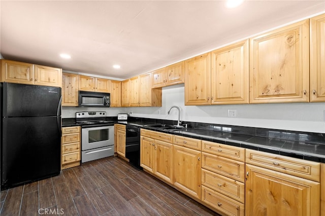 kitchen with dark wood-style flooring, recessed lighting, light brown cabinetry, a sink, and black appliances