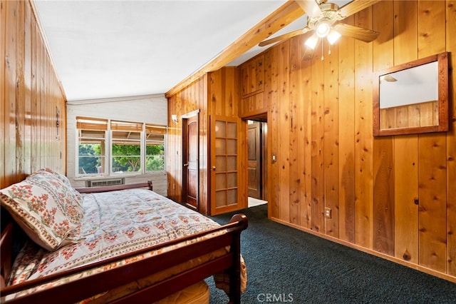 bedroom featuring lofted ceiling, carpet, a ceiling fan, and wooden walls