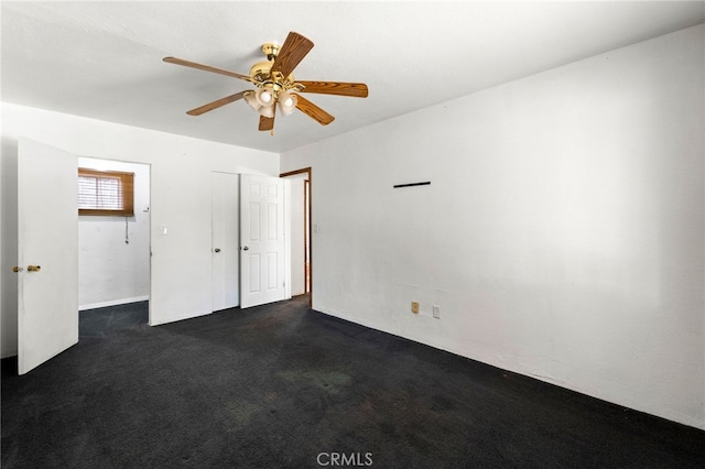 unfurnished bedroom featuring a closet, dark carpet, and a ceiling fan