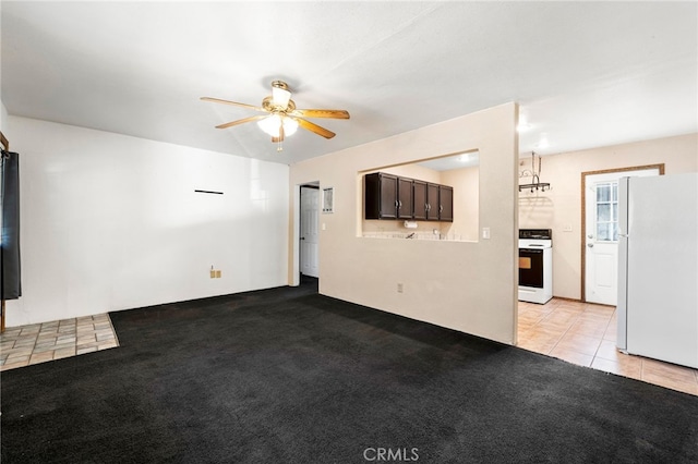 unfurnished living room with a ceiling fan, light colored carpet, and light tile patterned flooring