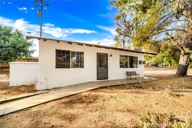 ranch-style house with fence and stucco siding