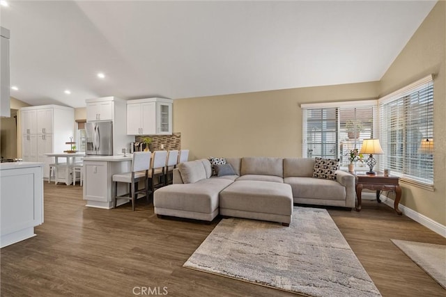 living area featuring dark wood finished floors, vaulted ceiling, baseboards, and recessed lighting