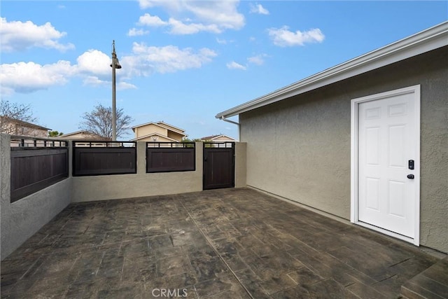 view of patio featuring a gate and fence