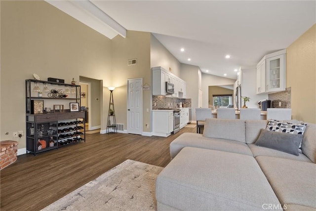 living room with high vaulted ceiling, visible vents, baseboards, beamed ceiling, and dark wood finished floors