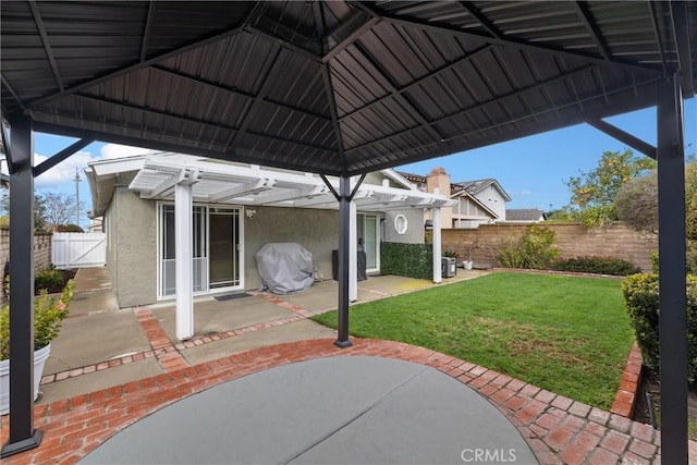 view of patio / terrace featuring a grill, a gate, fence, and a gazebo