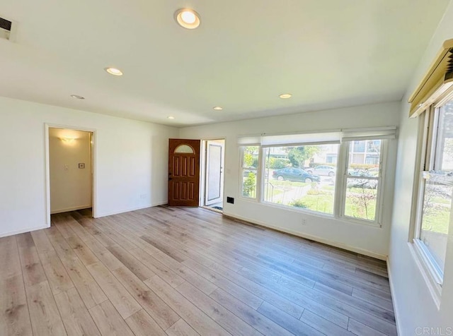 spare room with light wood-type flooring, visible vents, baseboards, and recessed lighting