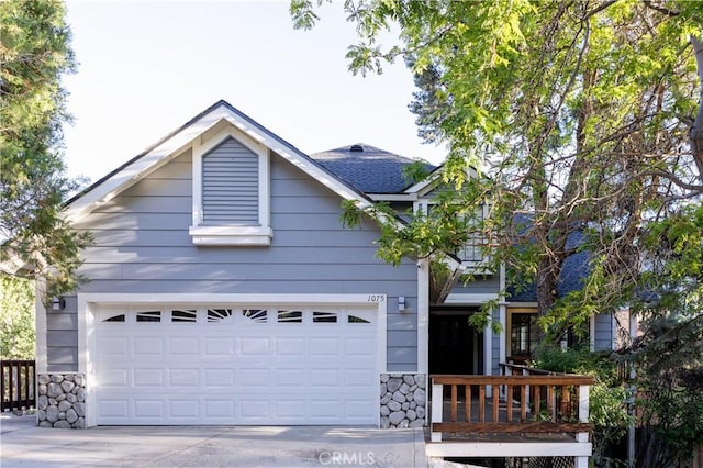 view of front facade with a garage, stone siding, and concrete driveway