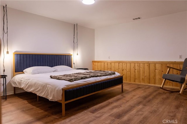 1075 Rivera Dr, Wrightwood, CA 92397 - bedroom with a wainscoted wall, wood finished floors, and visible vents