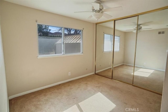 unfurnished bedroom with a closet, carpet flooring, visible vents, and baseboards