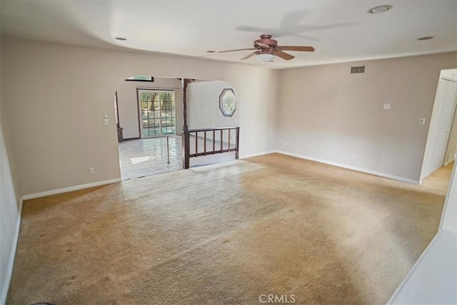 carpeted empty room featuring visible vents, ceiling fan, and baseboards