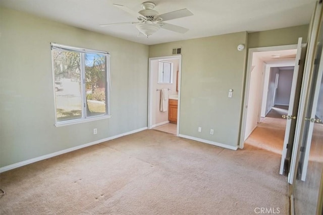 unfurnished bedroom featuring light colored carpet, visible vents, ceiling fan, ensuite bath, and baseboards