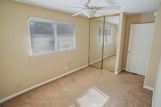 unfurnished bedroom with carpet, a closet, ceiling fan, and baseboards