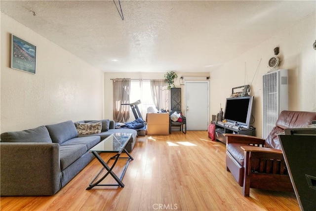 living room with light wood-style flooring and a textured ceiling