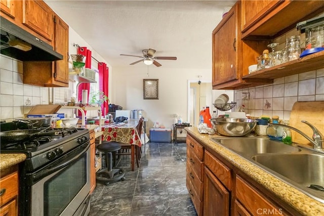 kitchen with under cabinet range hood, a sink, a ceiling fan, tasteful backsplash, and gas stove