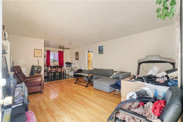 living room with a ceiling fan and light wood-style floors