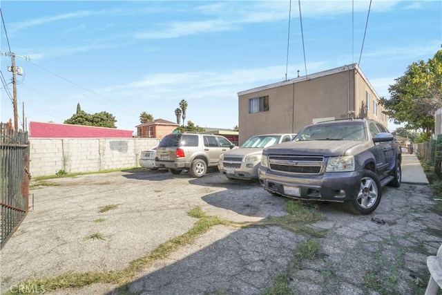 uncovered parking lot featuring fence