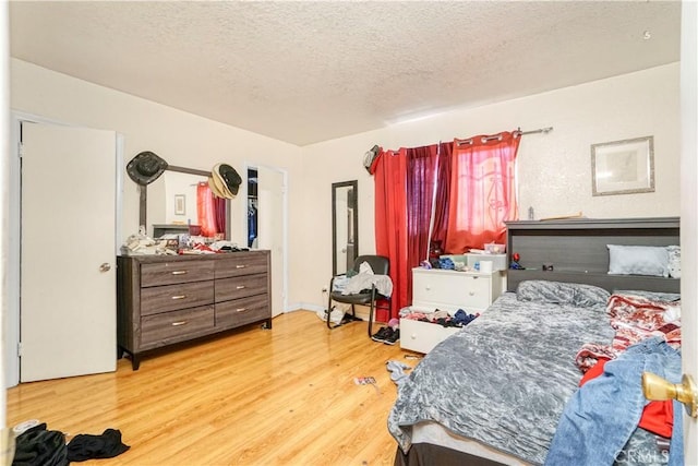 bedroom with a textured ceiling and wood finished floors