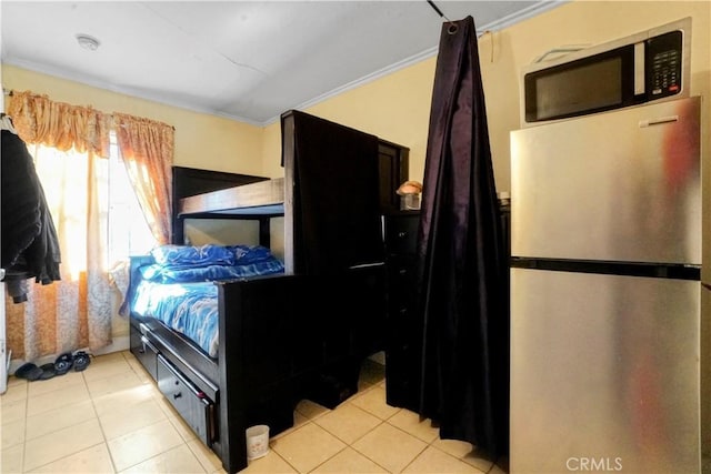 bedroom featuring light tile patterned floors, freestanding refrigerator, and crown molding