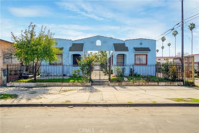 mediterranean / spanish-style home featuring a fenced front yard and stucco siding