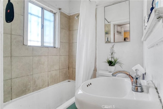 full bathroom with toilet, a sink, and shower / tub combo with curtain