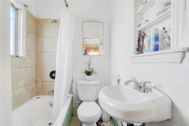 bathroom with toilet, a healthy amount of sunlight, shower / bath combo with shower curtain, and a sink