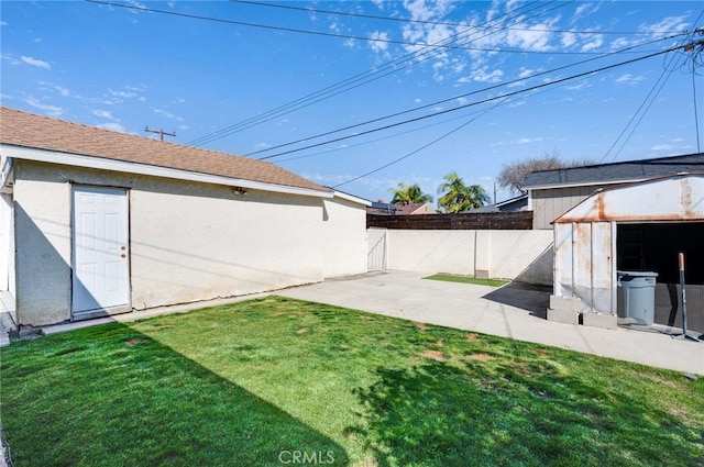 view of yard with a shed, a patio area, fence, and an outdoor structure