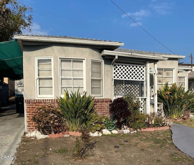 view of side of property with stucco siding and brick siding