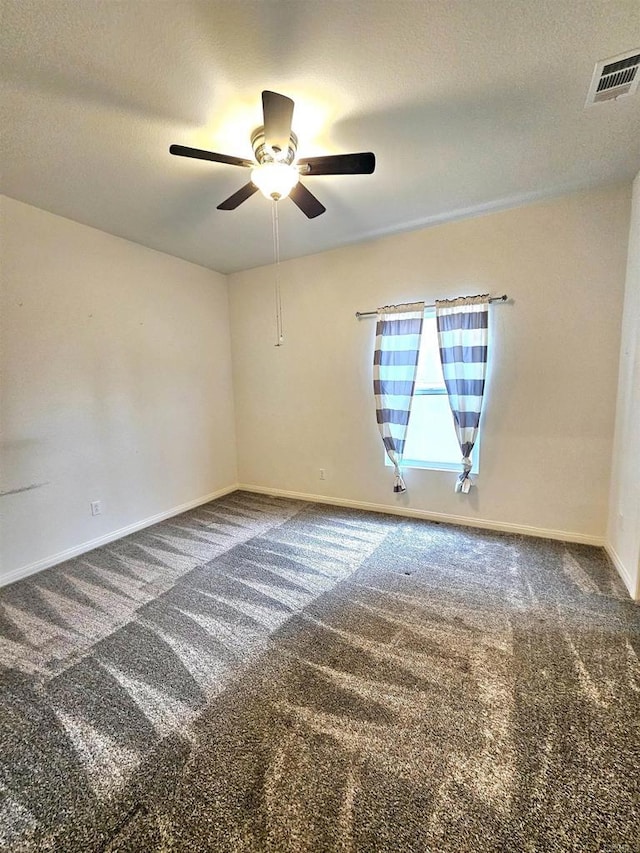 carpeted empty room featuring visible vents, baseboards, a textured ceiling, and a ceiling fan